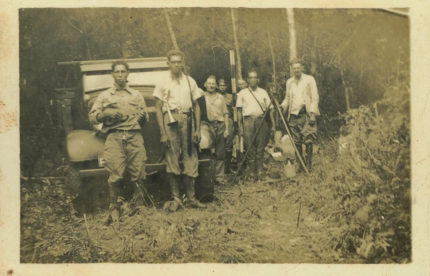 Fotografia de 1929 com homens numa clareira, um deles segurando cavaquinho